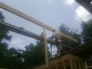 Carpenter setting a ridge beam over a new addition frame — Ice Dam Removal by Roofing Brothers in North Adams