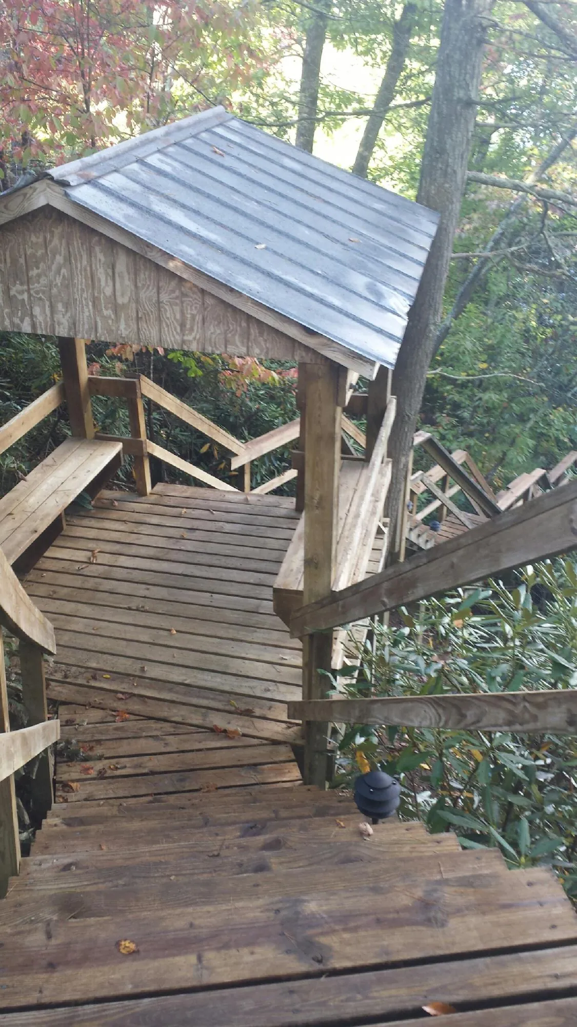 Metal roofed shelter over wooden steps on a wooded walkway — Skylight Repair & Installation work by our crew in North Adams