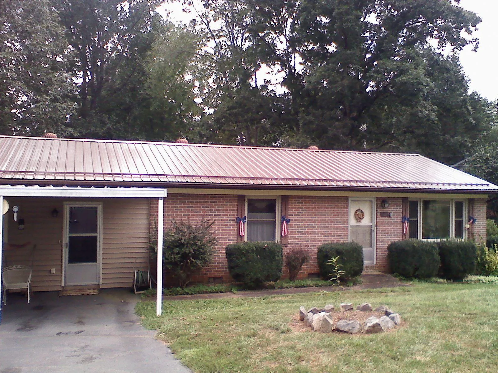 Bronze metal roof and carport on a brick ranch home — Roof Repair work by our crew in North Adams